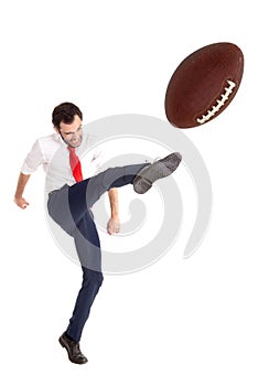 Businessman kicking a Rugby/football ball