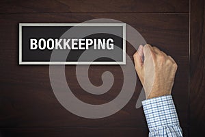 Businessman knocking on Bookkeeping office door photo