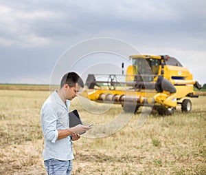 Businessman with laptop and cell phoen on field