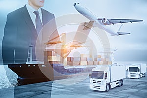 Businessman with laptop computer standing on abstract double exposure background with cargo airplane, truck and ship. Business,