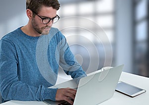 Businessman with laptop at desk with bright background