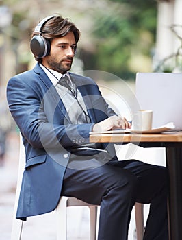 Businessman, laptop and headphone working in cafe, internet and social media for online meeting and remote work photo