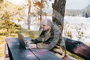 Businessman with laptop during his vacations in forest