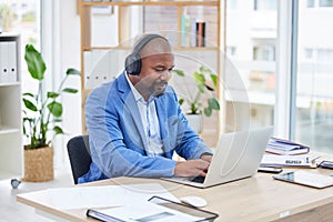 Businessman, laptop and listening to music, headphones and online marketing research at desk in office. Black man