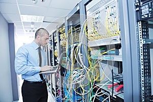 Businessman with laptop in network server room