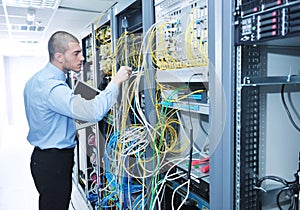 Businessman with laptop in network server room
