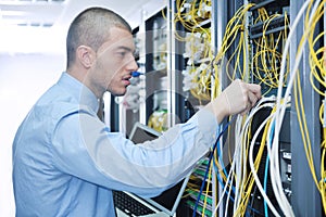 Businessman with laptop in network server room