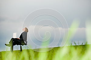 Businessman with laptop relaxing outdoors