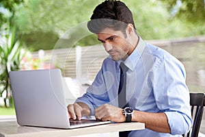 Businessman, laptop and research in outdoor cafe, website and b2b for plan or internet. Professional person, networking