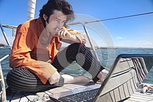 Businessman with laptop on sailboat