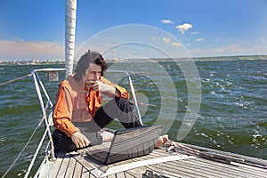 Businessman with laptop on sailboat