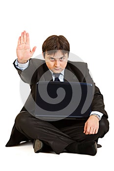 Businessman with laptop showing stop gesture