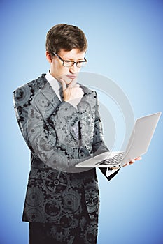 Businessman with laptop in suit with gears