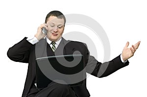 Businessman with laptop talking on phone