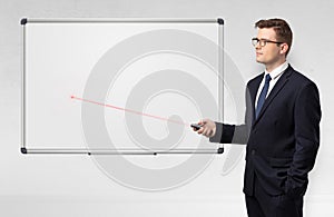 Businessman with laser pointer and copyspace white blackboard