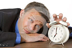 Businessman Leaning On Desk Watching Clock