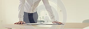 Businessman leaning on his desk with paperwork in front of him