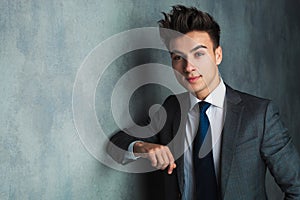 Businessman leaning his elbow against wall and looks away