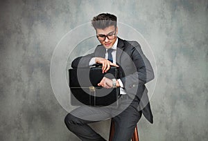 Businessman leaning his elbow against wall and looks away