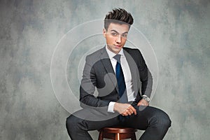 Businessman leaning his elbow against wall and looks away