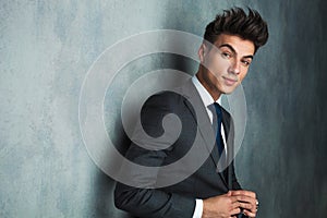 Businessman leaning his elbow against wall and looks away