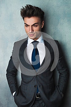 Businessman leaning his elbow against wall and looks away