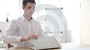 Businessman Leaving Office after Closing Laptop at Work