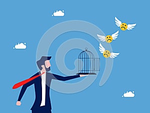 Businessman let the sad face icon fly out of the cage. Liberation of pessimism and freedom