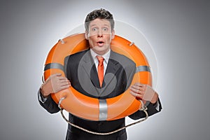 Businessman with a life buoy. Surprised businessman standing wit