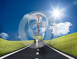 Businessman in light bulb with wind turbines and solar panels