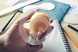 Businessman with lightbulb on desk in workplace.Ideas,creativity,inspiration concept