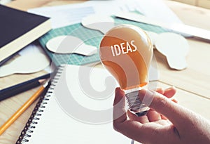 Businessman with lightbulb on desk in workplace.Ideas,creativity,inspiration concept