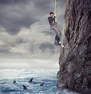 Businessman is likely to fall into the sea with sharks. concept of problems and difficulty in business