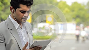 Businessman listening music on a digital tablet