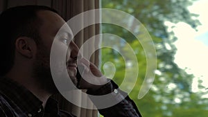 Businessman listening to someone on the phone in a train.