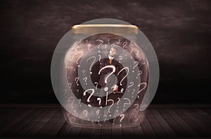 Businessman locked into a jar with question marks concept