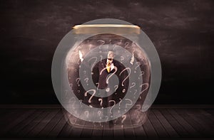 Businessman locked into a jar with question marks concept