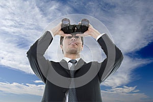 Businessman looking through binoculars