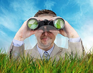 Businessman looking through binoculars