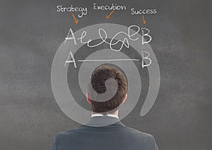 Businessman looking at business terms on chalkboard