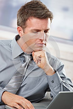 Businessman looking down at computer