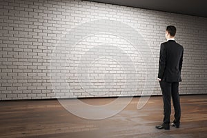 Businessman looking at empty brick wall