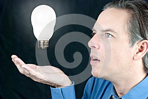Businessman Looking At Floating Lightbulb
