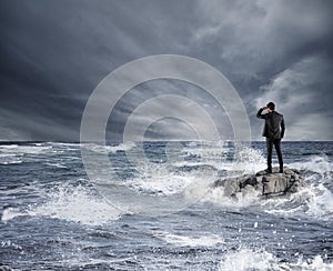 Businessman looking for the future during storm in the sea. Concept of economic crisis and problem