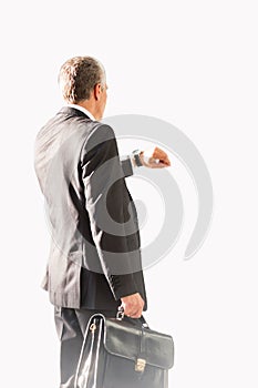 Businessman looking on his watch while waiting for boarding in airport