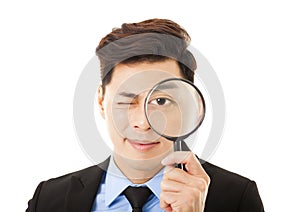 Businessman looking through magnifying glass