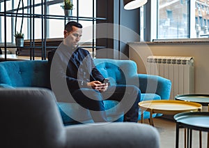 Businessman looking at the mobile phone in the office lounge