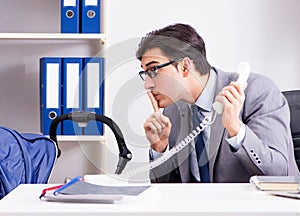 Businessman looking after newborn baby in office