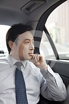 Businessman looking out car window