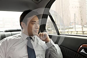 Businessman looking out car window